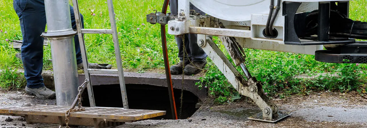 Saugfahrzeug über einem geöffneten Kanalschacht